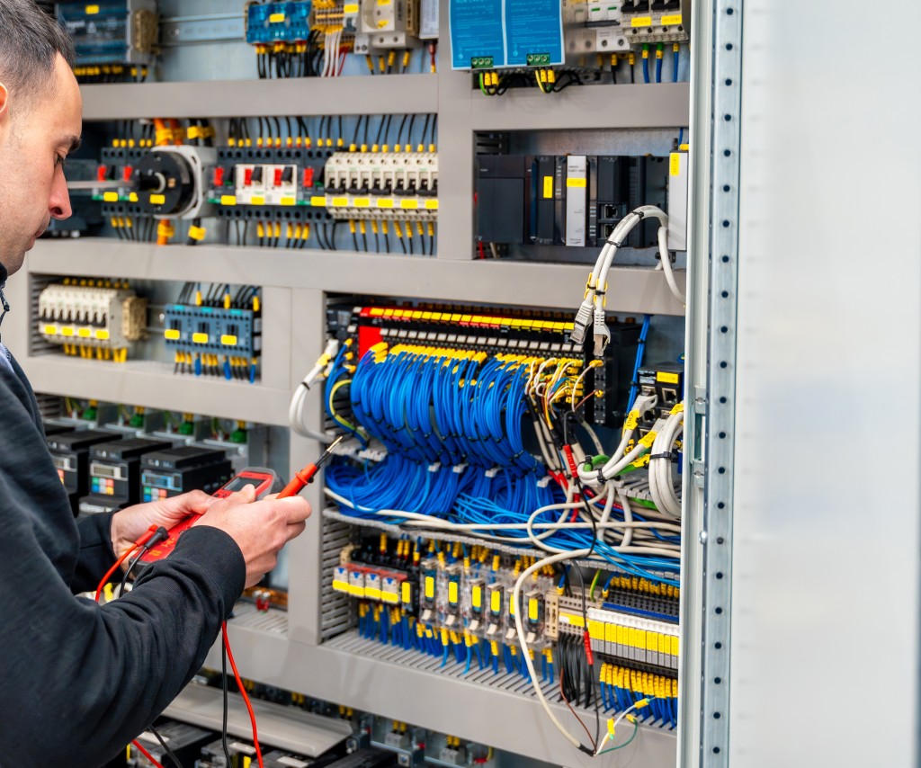 Electrician installing a distribution board during a commercial fit-out.